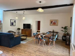 a living room with a couch and a table and chairs at gite 4 le refuge in Aubeterre-sur-Dronne