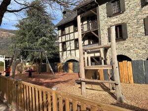 a wooden playground in front of a building at Appartement spacieux en duplex in Saint-Lary-Soulan +11 photos
