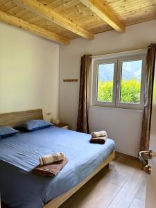 a bedroom with a bed with blue sheets and a window at Wild Side in Mollia +13 photos