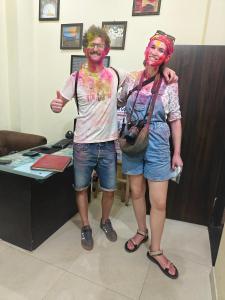 a man and a woman standing in front of a desk at The Pink Nest - Backpackers Abode in Jaipur
