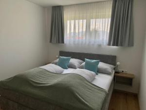 a bedroom with a large bed with blue pillows at Auszeit am Mondseeberg in Tiefgraben