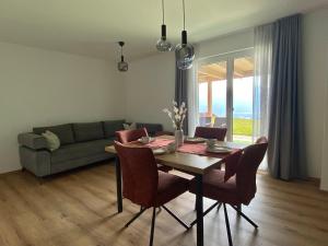 a dining room with a table and chairs and a couch at Auszeit am Mondseeberg in Tiefgraben