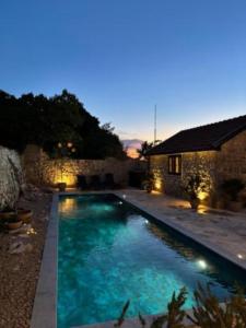 a swimming pool in front of a house at night at Vila Espinosa in Trebinje
