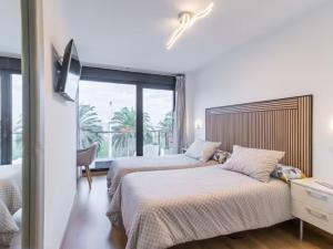 a hotel room with two beds and a window at Alojamientos Marte apartamento a pie de playa y garaje in Suances