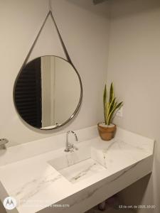 a bathroom with a sink and a mirror at Flat no Garden 2 in Rondonópolis