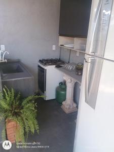 a small kitchen with a stove and a refrigerator at Flat no Garden 2 in Rondonópolis