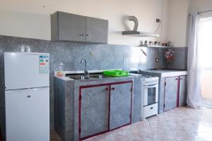 a kitchen with a sink and a white refrigerator at aparthotelboavista-net in Sal Rei