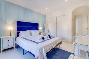 a blue and white bedroom with a large bed at Suites By The River in Ferragudo