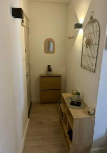 a bathroom with a sink and a bird cage on the wall at Le petit cocon côtois in La Côte-Saint-André