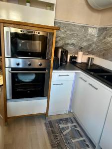 a kitchen with a stove and a microwave at Le petit cocon côtois in La Côte-Saint-André