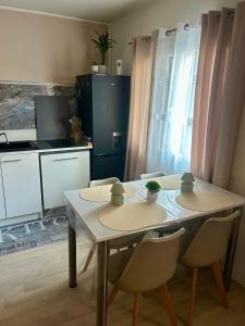 a kitchen with a table and chairs in a room at Le petit cocon côtois in La Côte-Saint-André