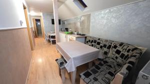 a kitchen with a white table and a table and chairs at Casa El Gringo in Tîrnăveni