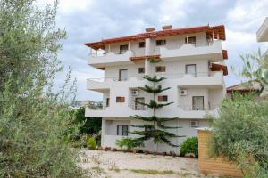 a white building with a tree in front of it at Vila Balani in Ksamil