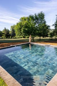 a woman is standing next to a swimming pool at château de Puymoger in Javerlhac-et-la-Chapelle-Saint-Robert