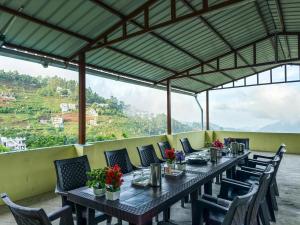 a long table with chairs and flowers on it at Kodai Hillscape in Kodaikānāl