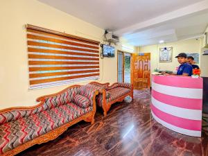 two men in a room with couches and a bar at Kodai Hillscape in Kodaikānāl