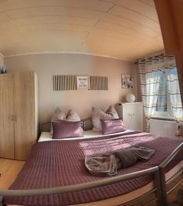 a bedroom with a bed with purple sheets and pillows at Top location central in Rüsselsheim