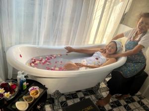 two women and a baby in a bathtub filled with confetti at Ruen Rinna home stays in Surin