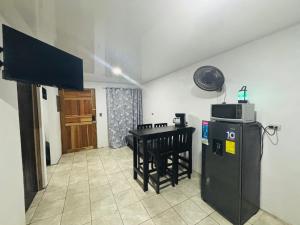 eine Küche mit Kühlschrank und ein Tisch mit Mikrowelle in der Unterkunft Izzy Blue House in Talamanca