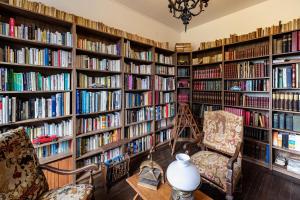 a library with large book shelves filled with books at château de Puymoger in Javerlhac-et-la-Chapelle-Saint-Robert