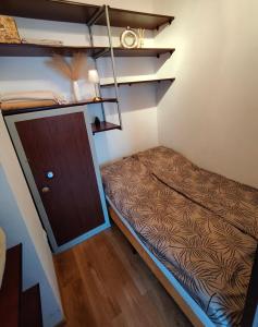 a small room with a bed and a closet at Serce Suwałk in Suwałki
