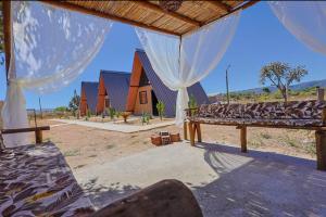 a view of a room with a bed and a house at Chalés Vale da Luma in Cavalcante