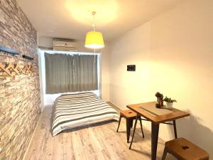 a small room with a bed and a table at Guest House Re-worth Yabacho1 302 in Nagoya