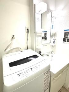 a kitchen with a washing machine and a sink at Guest House Re-worth Yabacho1 302 in Nagoya