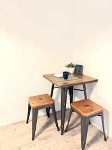 a wooden table with two stools and a table with a laptop at Guest House Re-worth Yabacho1 302 in Nagoya
