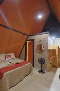 a bedroom with a bed and a tv on a wall at Chalés Vale da Luma in Cavalcante