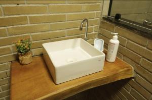 a white sink sitting on top of a wooden counter at Chalés Vale da Luma in Cavalcante +86 photos