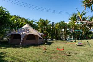 a tent with a swing set and a playground at Ryukyu Garden in Nanjo