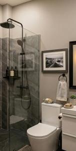 a bathroom with a toilet and a glass shower at Mutamba Prime Stay in Luanda