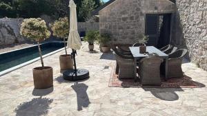 a patio with a table and chairs and an umbrella at Vila Espinosa in Trebinje