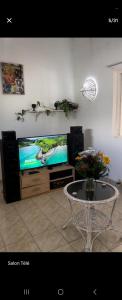 a living room with a table and a television at Naturelle Évasion in Grand-Baie