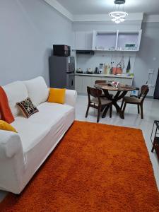 a living room with a white couch and a table at Haven Place 254-near JKIA,SGR with Self-Check in & Free Parking in Nairobi