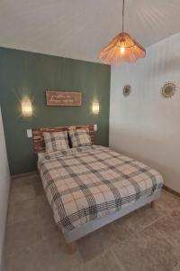 a bed in a room with a green wall at Maison pour 6 personnes in Le Bugue