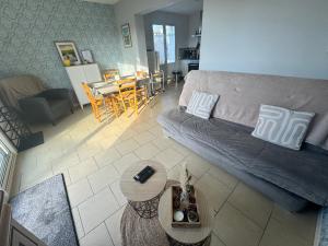 a living room with a couch and a table at Les Iles d'ici in Rochefort