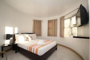 a bedroom with a bed and a flat screen tv at Bluewaves Westcliff Villa in Boracay