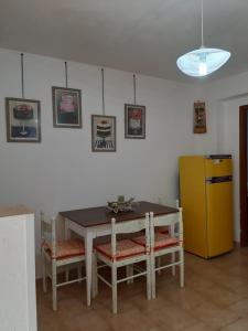 a kitchen with a table and a yellow refrigerator at Appartamento Tavernetta Corallo Rosso in Isca Marina