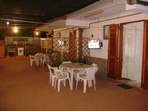 a room with a table and chairs and a television at Appartamento Tavernetta Corallo Rosso in Isca Marina