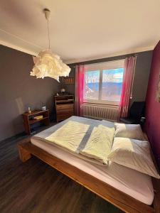 a bedroom with a large bed and a chandelier at Pepper House in La Chaux-de-Fonds