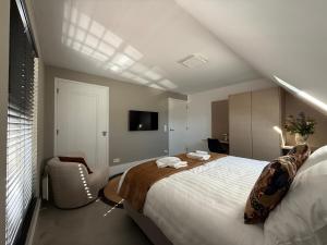 a bedroom with a large bed and a chair at B&B Louwi in Breugel