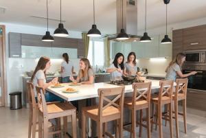 a group of women sitting around a kitchen table at The Strand Waterfront Apartment with 3 Bedrooms, 4 Bathrooms, Private Garage in Sliema