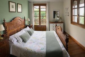 a bedroom with a large bed with a wooden headboard at Casa Rural Galain Ultzama-Navarra in Lizaso