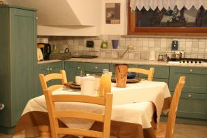 a kitchen with a table with chairs and a tableablish at B&B Lo Tatà in Fenis