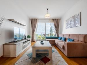 a living room with a couch and a tv at Tamariz Flat in Santa Cruz