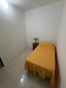 a bedroom with a bed with a yellow blanket at Apart Sur Catriel in Catriel