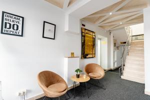 a room with two chairs and a table and stairs at Bofima Apartments in Kotor