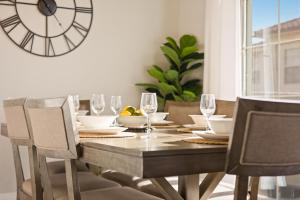 a dining room table with chairs and a clock on the wall at Pool, lazy river, pickle ball, sleeps 14, fire pit in Washington